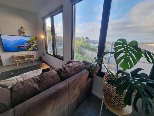 a living room with a couch and a large window at Luxurious stay at Doncaster East in Doncaster East