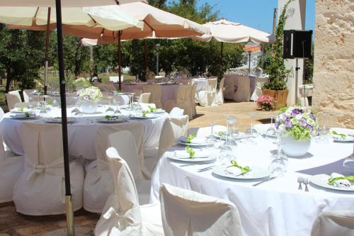 a table set up for a wedding with white tables and umbrellas at Masseria Valente in Ostuni