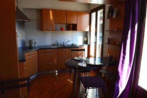 une cuisine avec des armoires en bois et une table avec des chaises dans l'établissement Appart 2 pièces 4 couchages BANYULS SUR MER BN140-043, à Banyuls-sur-Mer