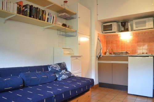 un salon avec un canapé bleu dans une cuisine dans l'établissement Appart studio 2 couchages CERBERE BN200-562, à Cerbère