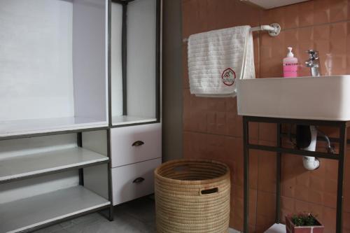 a bathroom with a sink and a basket at On Hill Lodge in Bloemfontein