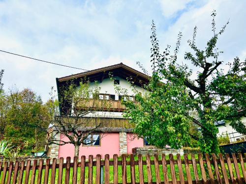 a pink and white building behind a fence at Haus Winkl 55 in Mariatal