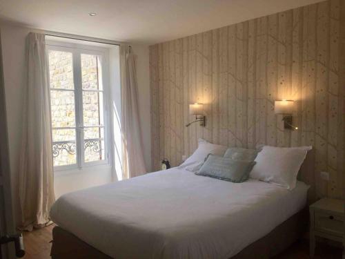 a bedroom with a white bed and a window at Gîte La Maisonnette à Auvers-sur-Oise in Auvers-sur-Oise