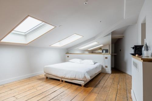 a bedroom with a bed and two skylights at B&B L'Escapade Bordelaise - Côté Jardin in Bordeaux