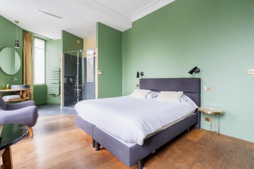 a bedroom with a large bed and green walls at B&B L'Escapade Bordelaise - Côté Jardin in Bordeaux