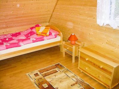 a small bedroom with a bed and a table at Całoroczne Domki Zacisze Hnatowego Berda w Wetlinie in Wetlina