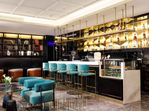 a restaurant with blue chairs and a bar at Pazhou XANA Deluxe International Hotel Pazhou Convention and Exhibition Center Nanzhou Metro Station Branch - Free Shuttle Bus to Canton Fair Complex During Canton Fair Period in Guangzhou