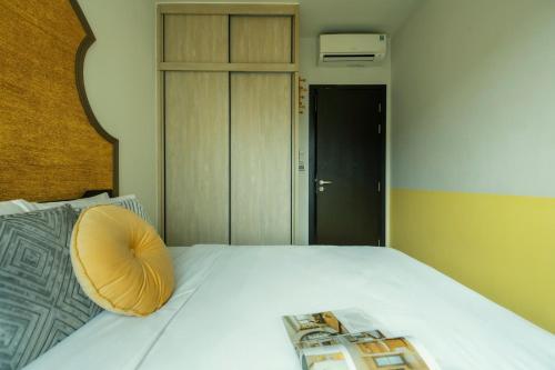 a bed with a pillow and a magazine on it at DingD0ng Home FelizEnVista 5-star facilities in Ho Chi Minh City