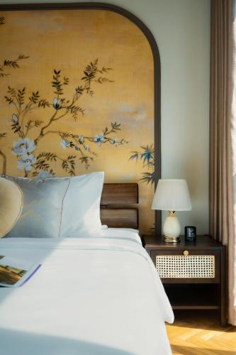 a bedroom with a bed with a painting on the wall at DingD0ng Home FelizEnVista 5-star facilities in Ho Chi Minh City