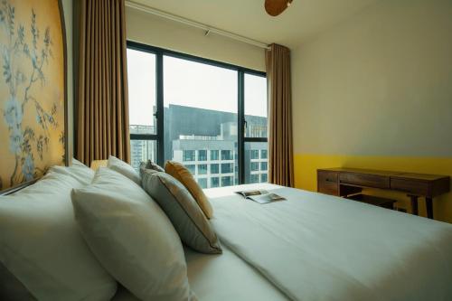 a bedroom with a large bed with a large window at DingD0ng Home FelizEnVista 5-star facilities in Ho Chi Minh City