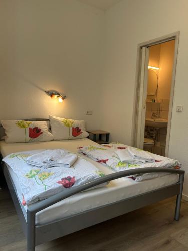 a bed in a room with a bedskirtspectspectssenalsenalsenalsenalsenal at Hotel Haus Schwan Köln in Cologne