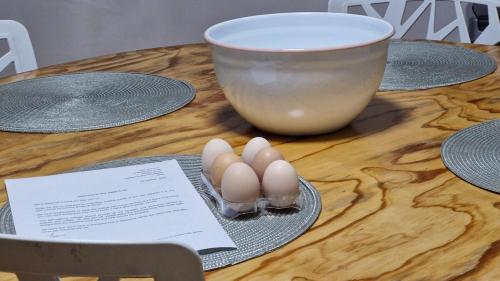 a table with two eggs on a plate and a bowl at Hen & Hound in Gqeberha