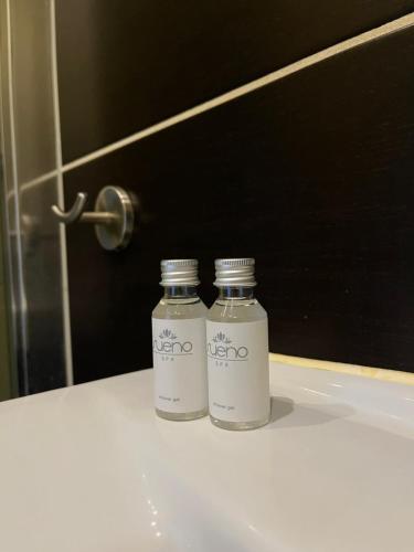 two bottles sitting on a bathroom counter in front of a mirror at Dom Wypoczynkowy Nad Wisłą in Puławy