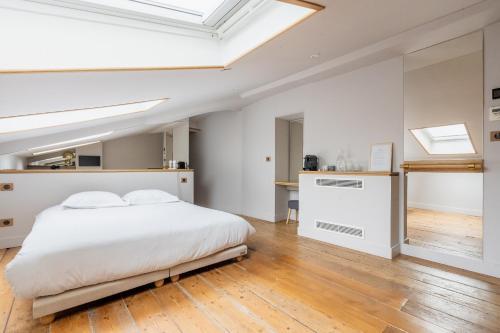 a bedroom with a white bed and a skylight at B&B L'Escapade Bordelaise - Côté Jardin in Bordeaux
