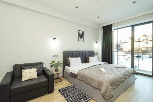 un dormitorio con una cama y un sofá en Lovely 1BR Apartment in Gudauri, en Gudauri