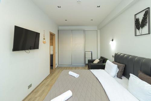 Un dormitorio con una cama y un televisor en una pared. en Lovely 1BR Apartment in Gudauri, en Gudauri