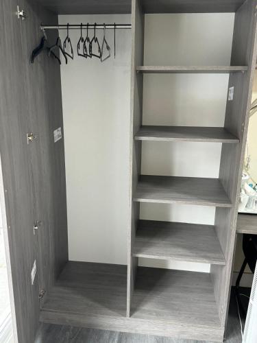 a closet with wooden shelves in a room at Premier City Centre Room- Ensuite in Nottingham