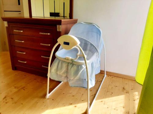a blue high chair in a room with a dresser at Samira's house Gusar in Hǝsǝnqala