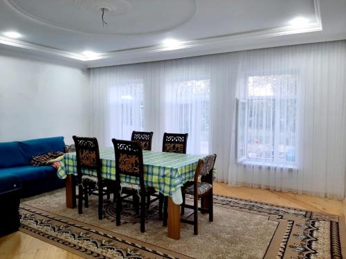 a dining room with a table and chairs and a couch at Samira's house Gusar in Hǝsǝnqala