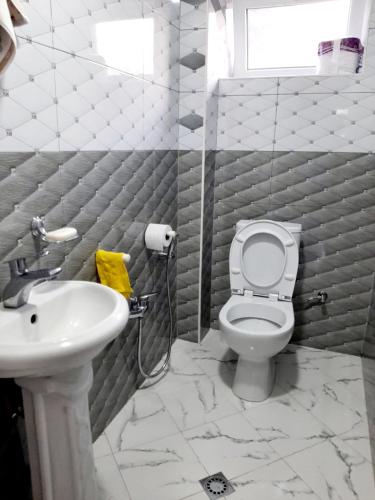 a bathroom with a toilet and a sink at Samira's house Gusar in Hǝsǝnqala