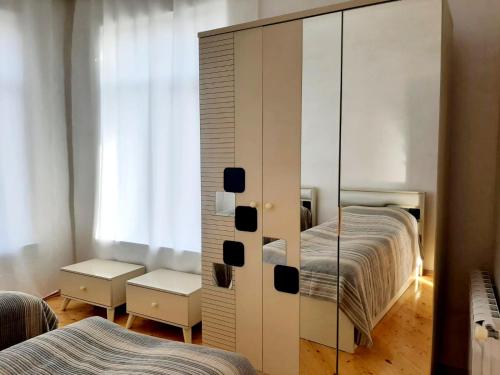 a mirrored cabinet in a bedroom with two beds at Samira's house Gusar in Hǝsǝnqala