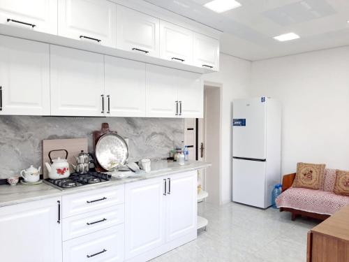 a kitchen with white cabinets and a white refrigerator at Samira's house Gusar in Hǝsǝnqala