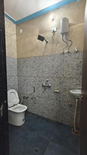a bathroom with a toilet and a sink at Ashirwad Hotel And Family Restaurant in Rīngas