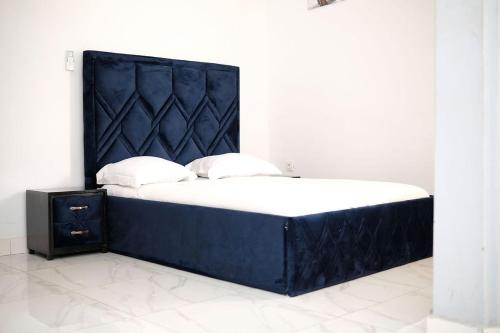 a bed with a black headboard in a room at Les Jardins de René Hébergements in Yaoundé