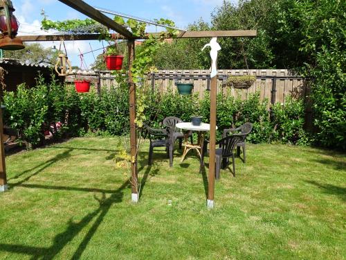 a garden with a table and chairs in the grass at B&B Piccardie in Emlichheim