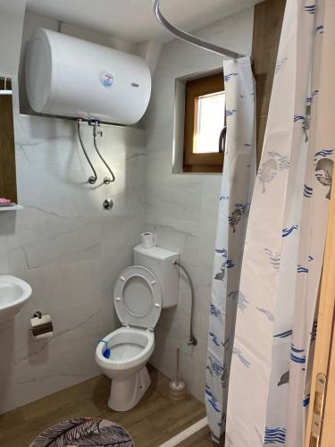 a small bathroom with a toilet and a window at Bungalows Ivan in Žabljak