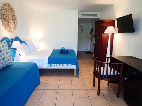 a hotel room with a bed and a chair at PIERRE & VACANCES Antigua 03 in Sainte-Luce