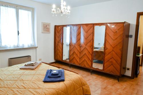 a bedroom with a large wooden wardrobe and a bed at CàGrande in Colombara
