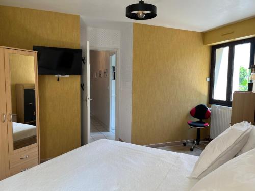 une chambre avec un lit et une télévision au mur dans l'établissement Chez Fabienne, tout à pied, à Saint-Malo