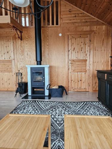 a living room with a stove in a room with wooden walls at The view of Skattungbyn in Skattungbyn