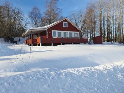 a red house with snow in front of it at The view of Skattungbyn in Skattungbyn