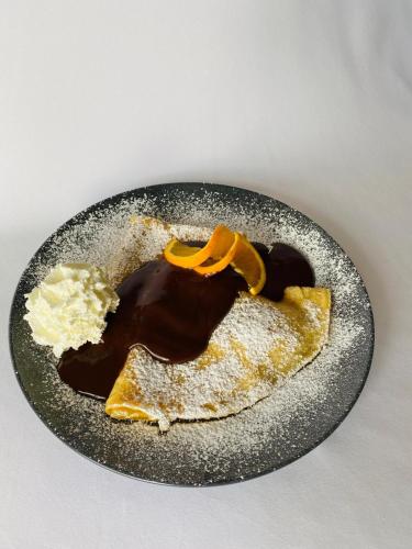a plate with a chocolate covered dessert on it at Hotel Römerstein in Loipersdorf bei Fürstenfeld