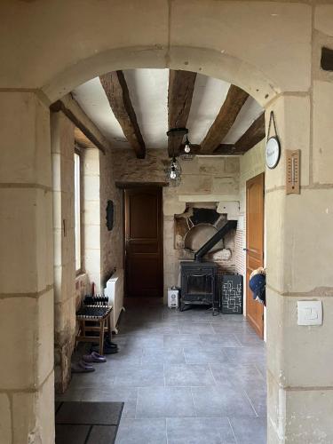 a large room with a fireplace in a stone building at EpLABONNE in Channay-sur-Lathan