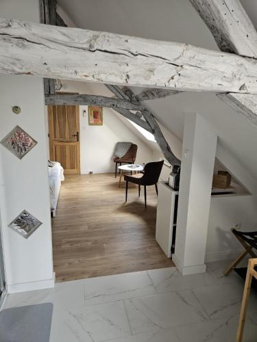 an attic room with a wooden floor and a table at EpLABONNE in Channay-sur-Lathan