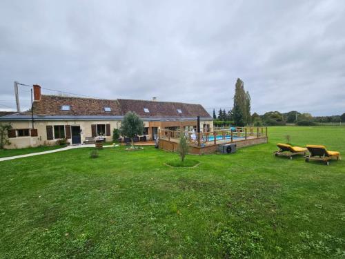 a house with a large yard with a deck at EpLABONNE in Channay-sur-Lathan