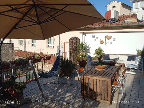 a patio with an umbrella and a table and chairs at Casa Irma Confortevole appartamento nel cetro di prato in Prato