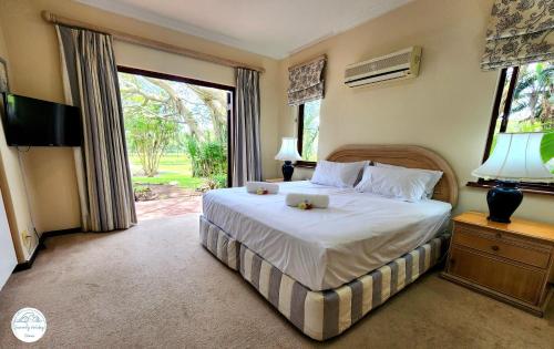 a bedroom with a bed and a large window at Villa G5 - Selborne Golf Estate in Pennington