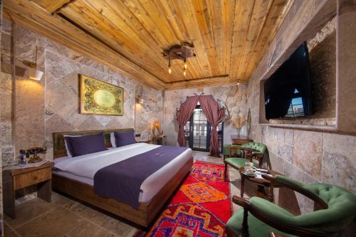 a bedroom with a bed and a tv in a room at Cappadocia Chiaro in Uçhisar