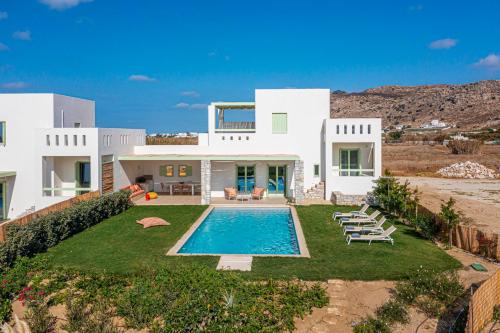 a large white house with a swimming pool at Plioni Villas With Private Pool & Suites With Hot Tub in Mikri Vigla