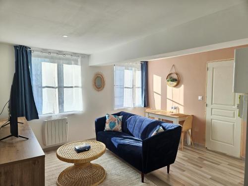 a living room with a blue couch and a table at Appartement T2 cosy à 5min à pieds de la gare in Valenciennes