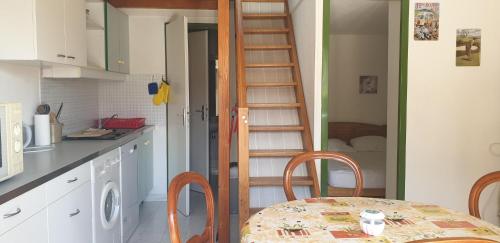 - une cuisine avec une table et un escalier dans une chambre dans l'établissement Petite maison en Ardeche, à Saint-Martin-dʼArdèche