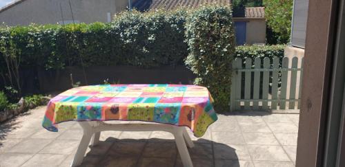 une table avec un tissu de table coloré assise sur une terrasse dans l'établissement Petite maison en Ardeche, à Saint-Martin-dʼArdèche