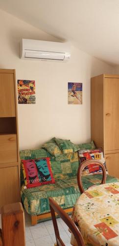 un salon avec un canapé et un lit dans l'établissement Petite maison en Ardeche, à Saint-Martin-dʼArdèche