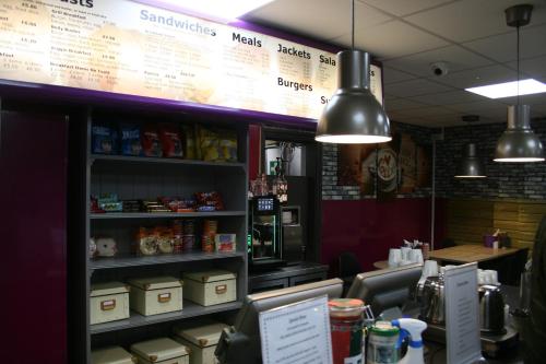 a fast food restaurant with a cash register and a counter at OYO Chris's Motel in Stokenchurch