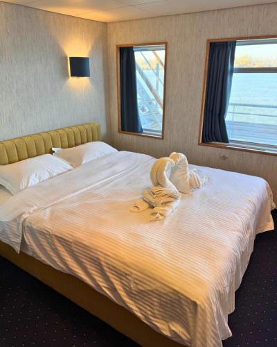 a bedroom with a large bed with towels on it at Boat Hotel Sofia in Ruse