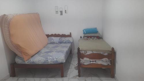 une petite pièce avec un lit et une chaise dans l'établissement Casa de praia itanhaem, à Itanhaém